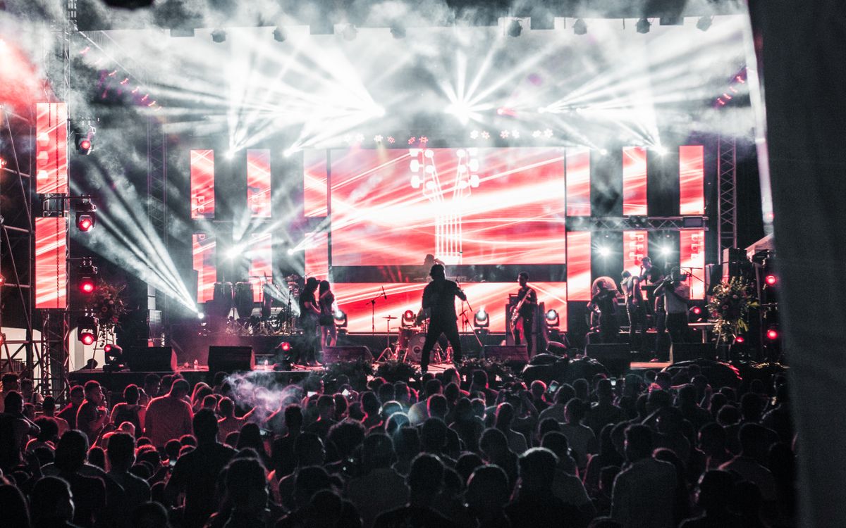 A band playing to a full house, seen from the back of the crowd.